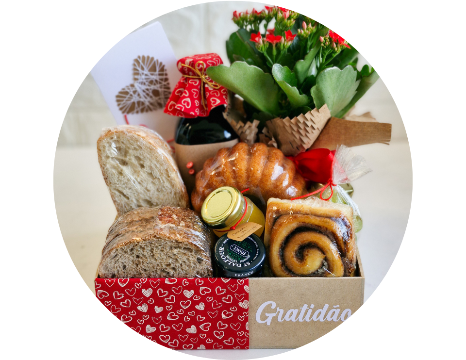 Inicio 1 Cesta de café da manhã Gratidão em caixa kraft com corações vermelhos. Contém pães fatiados de fermentação natural, bolo artesanal, geleia St. Dalfour, mel, suco e um vaso de flores vermelhas Kalanchoe com cartão de presente. Opção de presente afetivo em São Gonçalo.
